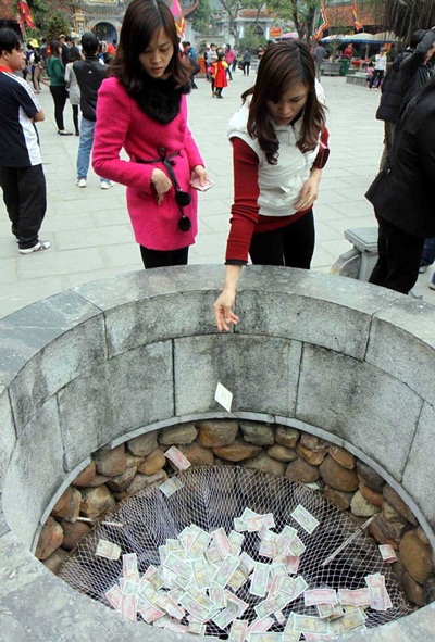 Lễ hội 2014 bị "tấn công" bởi... tiền lẻ! - 1 Du khách đua nhau đặt tiền lẻ tại lễ hội Chí Linh (Hải Dương). Ảnh TTXVN