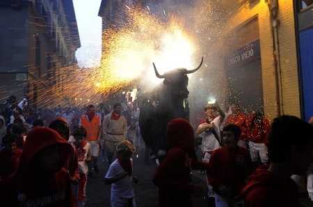 Những đứa trẻ cũng háo hức chạy theo chiếc xe diễu hành hình chú bò tót được gắn pháo hoa.