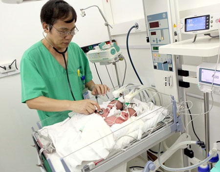 Hà Nội: Một ca sinh 4 em bé, 3 trai 1 gái - 1 TS Lợi khám cho các bé trong ca sinh tư. Ảnh: T.A