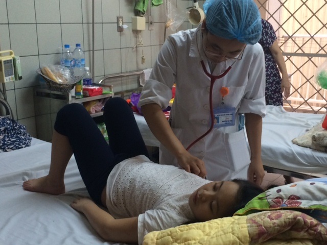 Tiếp nhận 10 trẻ viêm màng não, viêm não ngày cuối tuần - 1 Bác sĩ đang khám cho một bệnh nhi viêm màng não vi rút. Ảnh: H.Hải