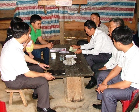 Đại diện chính quyền địa phương kiểm đếm số tiền bạn đọc gửi giúp bé Thắm 