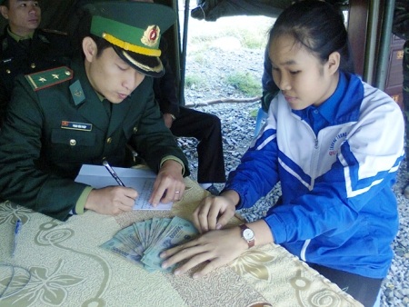 Một học sinh giao nộp 18 triệu đồng nhặt được tại Khu mộ Đại tướng - 1 Em Lê Thị Phương Ly đang bàn giao số tiền 18 triệu đồng cho Đồn Biên phòng Roòn
