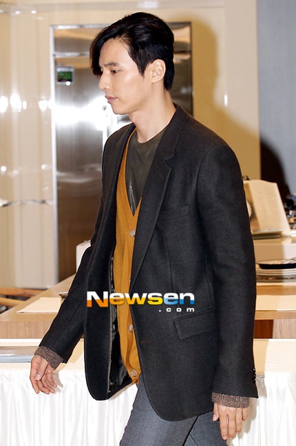 Won Bin mặc vest kiết hợp với áo len có phần nghiêm nghị.