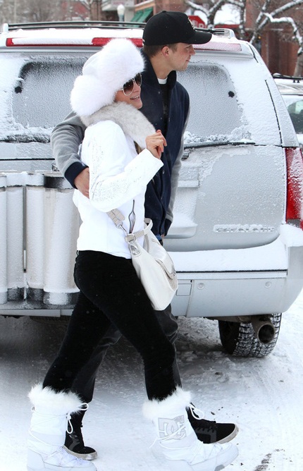 Paris Hilton ăn vận như một nàng công chúa tuyết với áo phao trắng, bốt trắng và túi xách cùng màu.