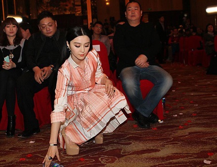 Người đẹp bất ngờ cúi xuống nhặt một vỏ chai đã uống cạn khi phát hiện nó nằm trên thảm đỏ.