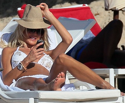 Cô nằm dài sưởi nắng và thỉnh thoảng lại kiểm tra điện thoại.