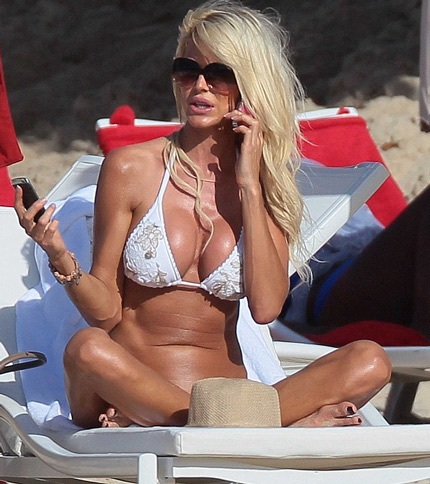 Cô nằm dài sưởi nắng và thỉnh thoảng lại kiểm tra điện thoại.