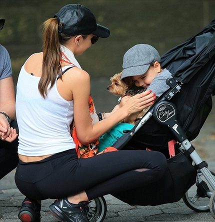 Cậu bé thích thú vui đùa cùng mẹ và chú cún cưng.