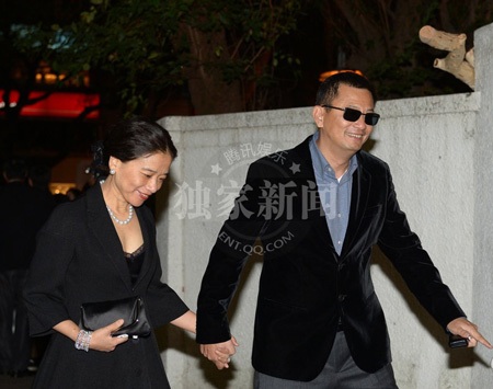 Đạo diễn Vương Gia Vệ nắm tay vợ vượt qua vòng vây của giới săn tin và người hâm mộ