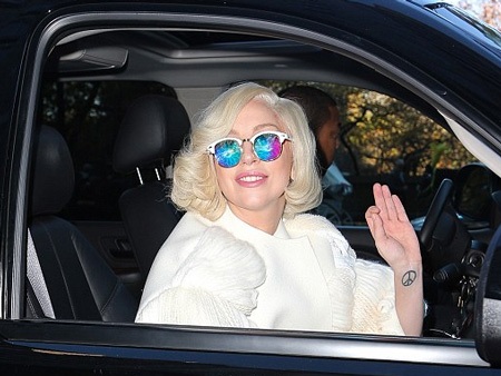 Nữ ca sĩ nổi tiếng vẫy tay chào người hâm mộ đang đứng bên ngoài khách sạn để chờ đón cô.