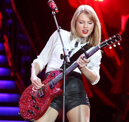 Cô ca sĩ 23 tuổi thể hiện khả năng chơi guitar trên sân khấu.