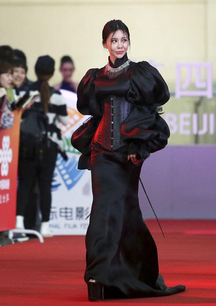 Củng Tân Lượng ăn mặc kỳ dị và để lộ gương mặt méo xệch vì nghiện dao kéo thẩm mỹ.