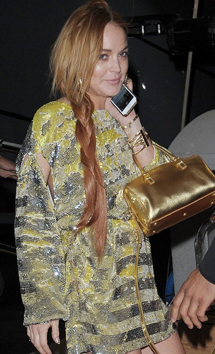 Lindsay cố gắng mỉm cười với phóng viên ảnh sau một chuyến bay dài.