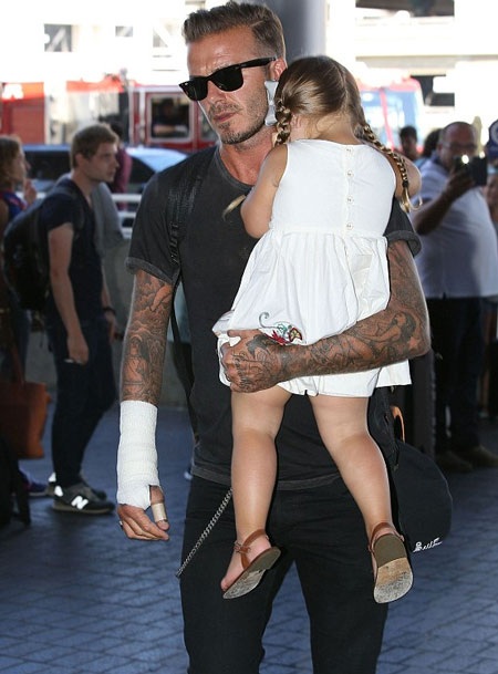 Bé Harper được tết bím rất đáng yêu tìm cách né giới săn tin bằng cách gục đầu lên vai bố.