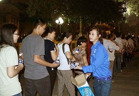 Tình nguyện viên phát nước cho đồng bào