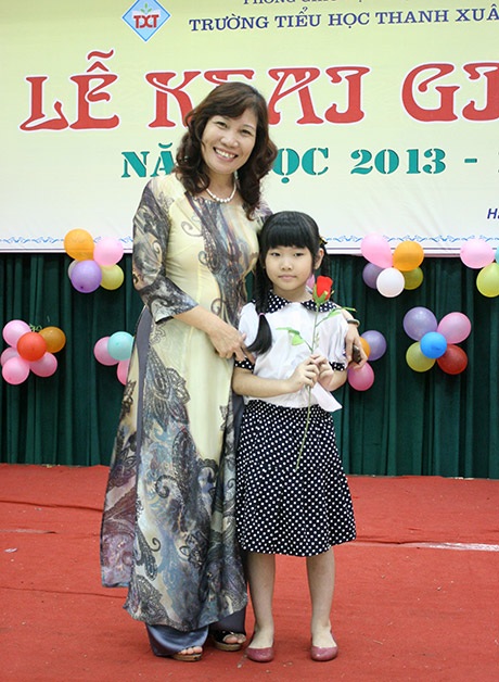 Một bé Heo Vàng mang hoa lên tặng cô hiệu trưởng