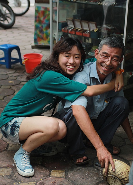 Nữ tình nguyện viên ôm chặt ông lão sửa xe