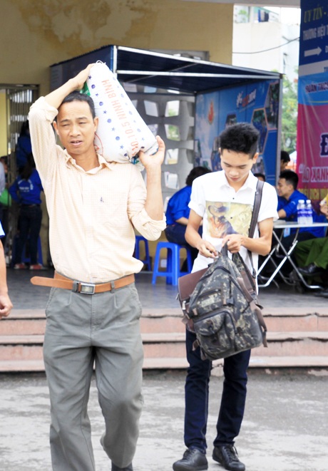 Phụ huynh giúp sĩ tử mang vác các bao tải nặng