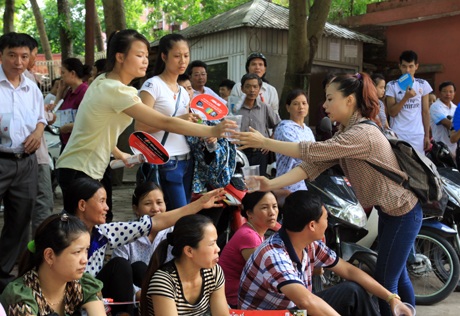 Các thành viên trong nhóm tranh thủ tiếp nước cho phụ huynh chờ đón sĩ tử