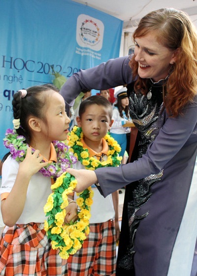 Học sinh lớp 1 được cô giáo trao vòng nguyệt quê, tượng trưng cho những món quà tri thức.