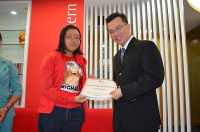 Ông Ong Khai Sheong – Phó Giám Đốc Nghiệp Vụ trao phiếu mua sách cho khách hàng Tôn Thanh Hương