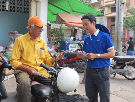 Đoàn viên thanh niên phát tờ rơi tuyên truyền cách tiết kiệm điện nước đến người dân
