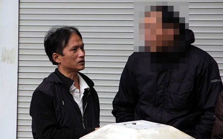 Hà Nội: Bị cưỡng chế nhà, ôm “bom xăng” cố thủ - 2 Một trong hai người cố thủ trong nhà (trái) đã chịu đi xuống.