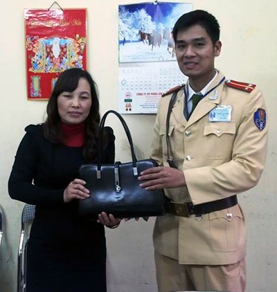 Hà Nội: CSGT trả lại nhiều tài sản cho người đánh rơi - 1 Trung úy Thành trao trả chiếc túi có nhiều tài sản giá trị cho chị Huyền.