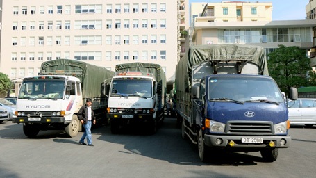 Nhiều xe tải chở hàng lậu bị giữ tại trụ sở công an.