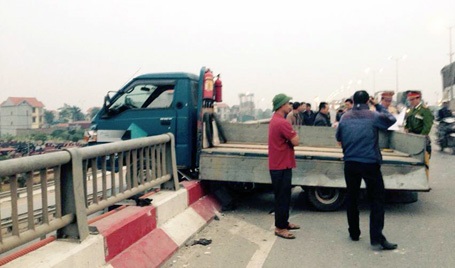 Chiếc xe tải húc đổ một đoạn lan can cầu Thanh Trì rồi nằm vắt vẻo trên thành cầu.