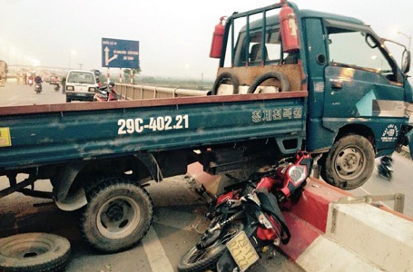 Chiếc xe máy bị ép chặt dưới gầm ô tô, người điều khiển bị hất văng xuống phía dưới đường gom.