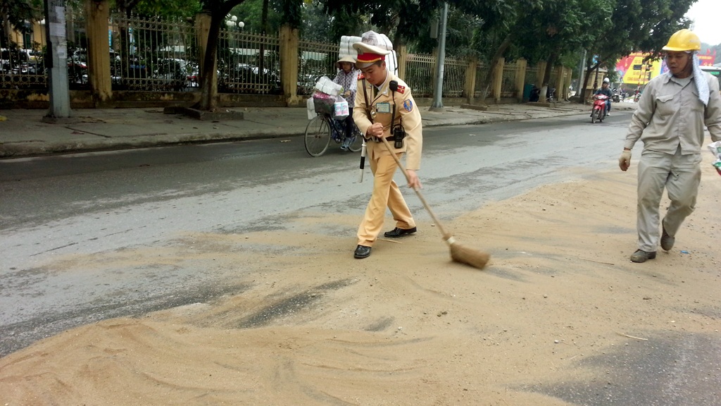 Hà Nội: Hàng loạt người “vồ ếch” vì đường trơn như bôi mỡ - 3 Rải cát làm sạch dầu trên mặt đường.