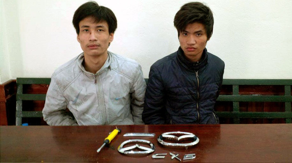 Hà Nội: Hai anh em họ rủ nhau đi trộm logo “xế” xịn - 1 Hai đối tượng Sơn và Mạnh cùng tang vật của vụ án.