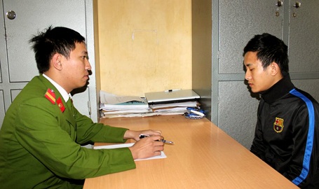 Hà Nội: Dùng búa đinh nện thẳng vào mặt lái xe ôm để cướp - 1 Điều tra viên lấy lời khai của Đặng Việt Đức.