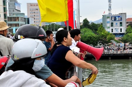 Một nữ cổ động viên dùng cả loa cầm tay và mũ để cổ vũ cho đội nhà