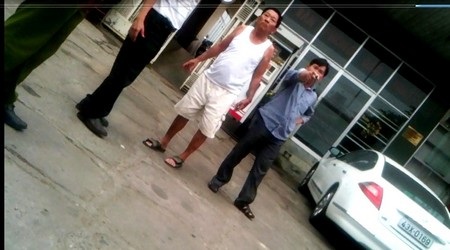 Chủ cây xăng giải vây xe dù, thóa mạ cảnh sát - 1 Ông Lịch (áo trắng) và con là ông Sơn có hành vi ngăn cản lực lượng Cảnh sát khi làm nhiệm vụ