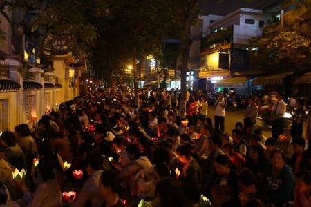 Người dân đứng tràn ra ngoài đường trong không khí trang nghiêm để cầu an