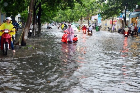 Do dưới đường ngập nước nên nhiều người phải đi xe máy lên vỉa hè