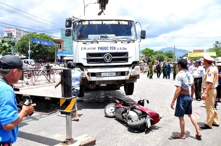 Lực lượng chức năng huy động xe cẩu nâng xe bê tông lên mới đưa xe máy ra ngoài