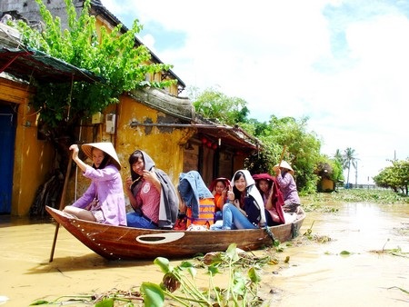 Du khách thích thú với việc thuê ghe đi chơi lũ ở Hội An