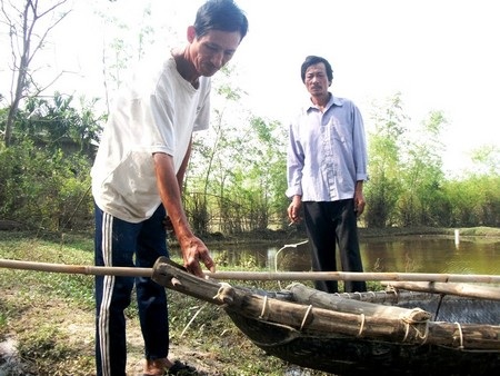 Ông Đỗ Văn Dũng (áo trắng) và Huỳnh Đình Thắng cùng chiếc xuồng vượt lũ cứu hai người gặp nạn
