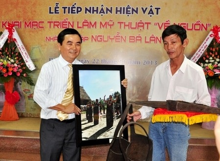 Ông Lâm Tứ Khoa (phải) trao tặng cung tên, gùi của đồng bào các dân tộc Cơtu ở Quảng Nam 