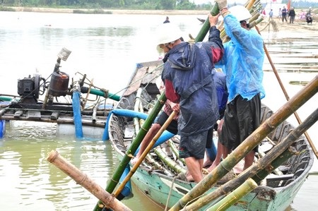 Dù lạnh buốt nhưng anh Huỳnh Thoa vẫn ngâm mình dưới nước trải bạt cho mái taluy cầu