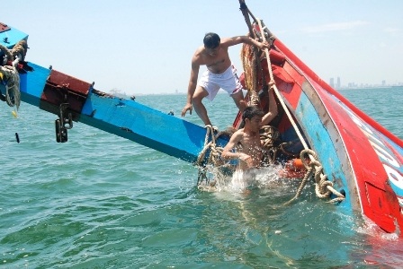 Các thợ lặn tiến hành cột dây tàu cá ĐNa 90152 để lai dắt vào bờ