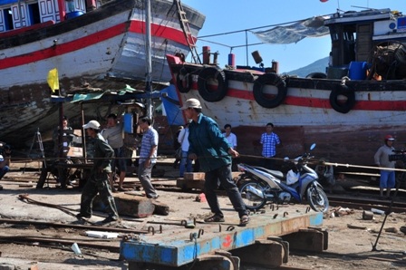 Công việc kéo tàu cá ĐNa 90152 đang được khẩn trương kéo vào bờ để sửa chữa