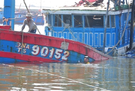 Các thợ lặn đang tiến hành cột dây để kéo tàu cá lên