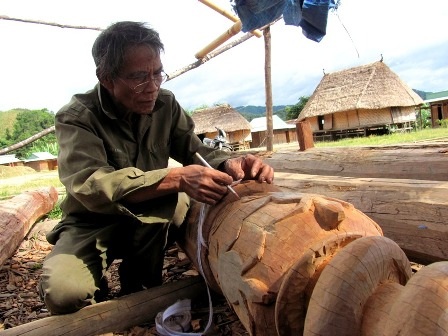 Già làng Bhling TrơNgâr (xã Avương) đang đo vẽ “thiết kế” để cho những người trẻ tự điêu khắc
