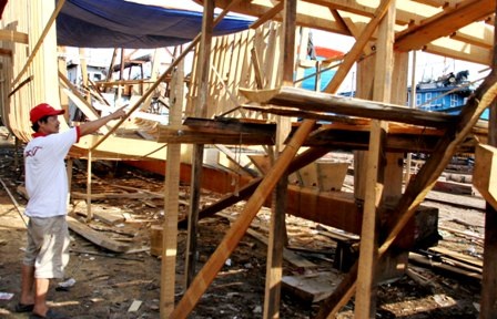 Anh Trần Văn Vốn bên cạnh con tàu đang đóng mới