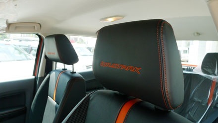 Tựa đầu với hàng chữ thêu nổi bằng chỉ đỏ