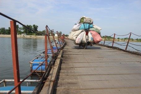 Quảng Trị: Người dân “thót tim” khi đi qua cây cầu phao xuống cấp - 3 Mỗi khi phương tiện chạy qua, mặt cầu bị rung lắc mạnh, ván gỗ bị rời ra.